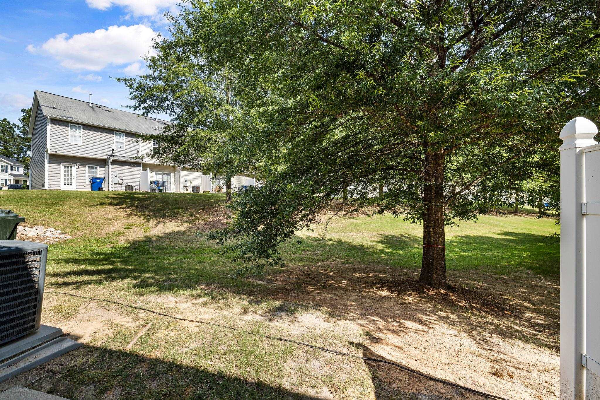 3853 Volkswalk Place Raleigh, NC 27610 - Photo 17 of 19 a view of a yard with plants and large trees