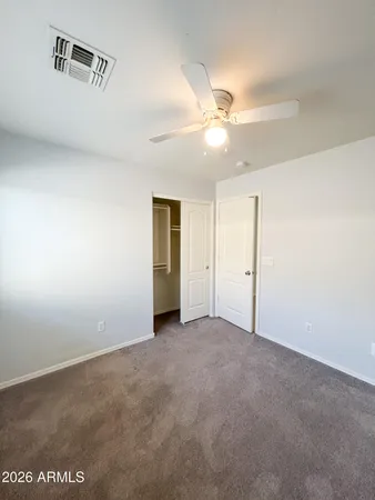 an empty room with a ceiling fan and a window
