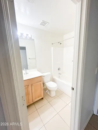 a bathroom with a granite countertop sink mirror vanity and toilet