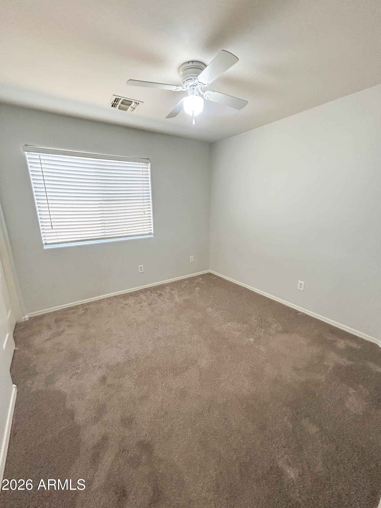 25645 West Dunlap Road Buckeye, AZ 85326 - Photo 18 of 27 an empty room with a ceiling fan and window