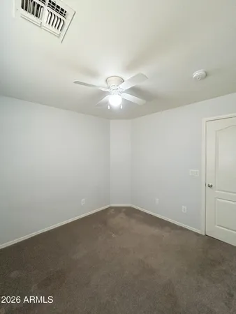 an empty room with a ceiling fan and a window