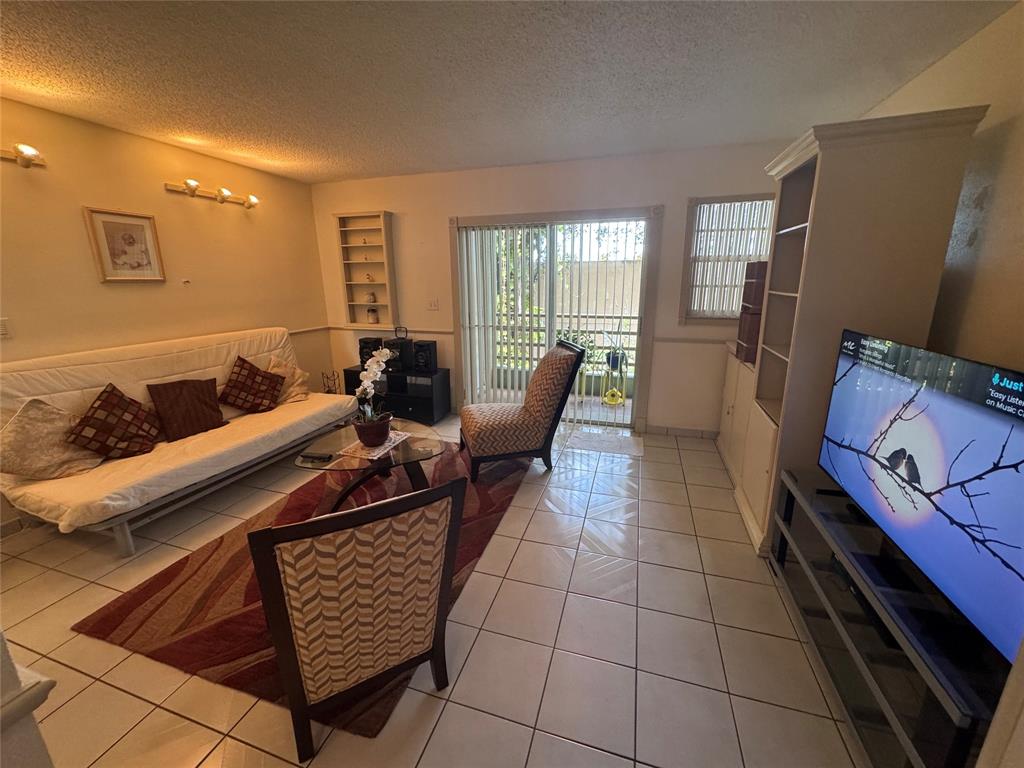 11183 Northwest 7th Street, Unit 202 Miami, FL 33172 - Photo 2 of 13 a living room with furniture and wooden floor