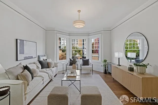 a living room with furniture chandelier and a large window
