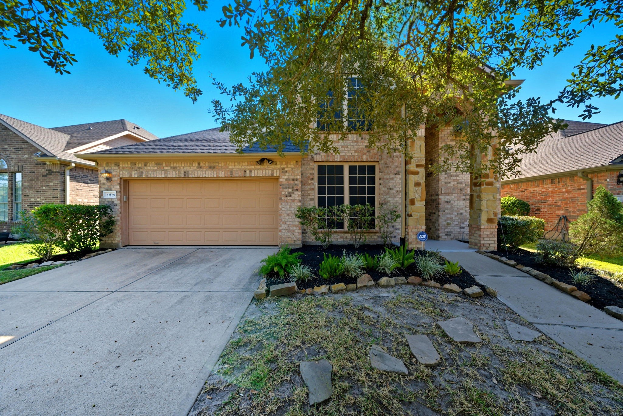 23139 Tranquil Spring Lane Katy, TX 77494 - Photo 1 of 22 This charming brick home features a three-car garage and a welcoming front entry. The landscaped yard includes a pathway and mature trees, offering shade and curb appeal. Perfect for a cozy, suburban lifestyle.