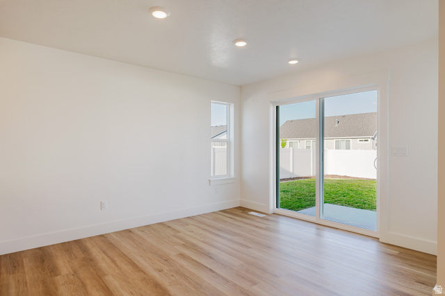 433 North 600 West Smithfield, UT 84335 - Photo 17 of 40 Spacious room featuring wood-finish flooring, recessed ceiling lighting, a large sliding glass door, and an additional window