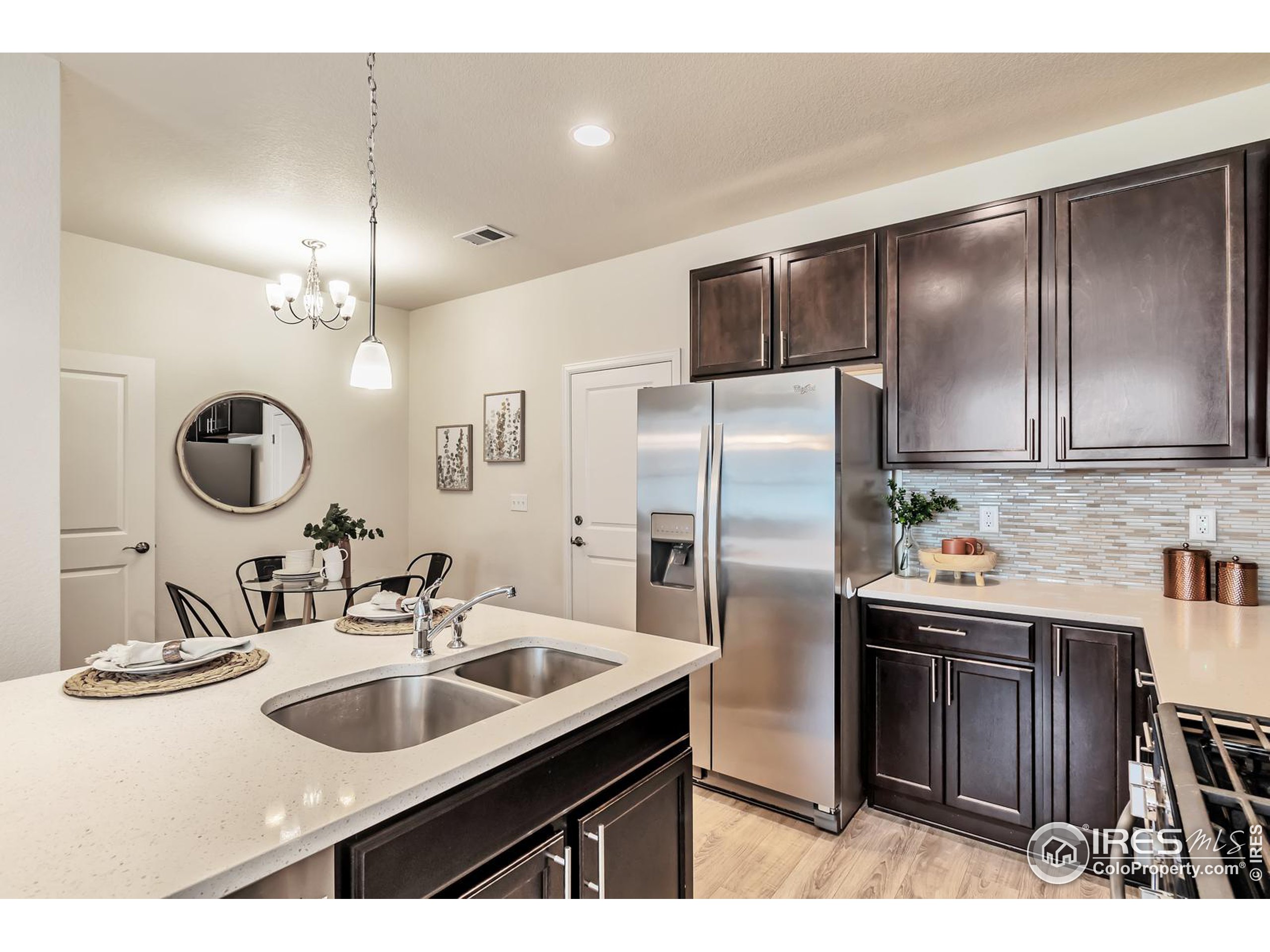15546 West 64th Loop, Unit C Arvada, CO 80007 - Photo 11 of 27 a kitchen with kitchen island granite countertop a sink and refrigerator