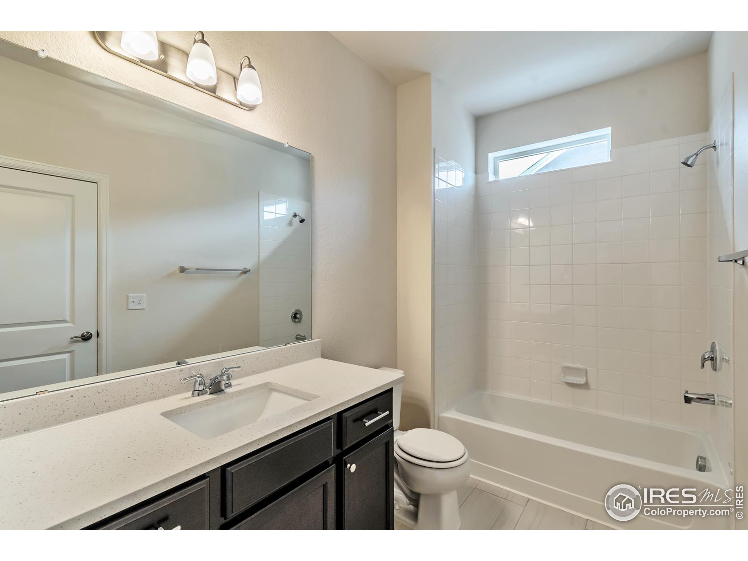 15546 West 64th Loop, Unit C Arvada, CO 80007 - Photo 19 of 27 a bathroom with a sink a toilet a mirror and bathtub