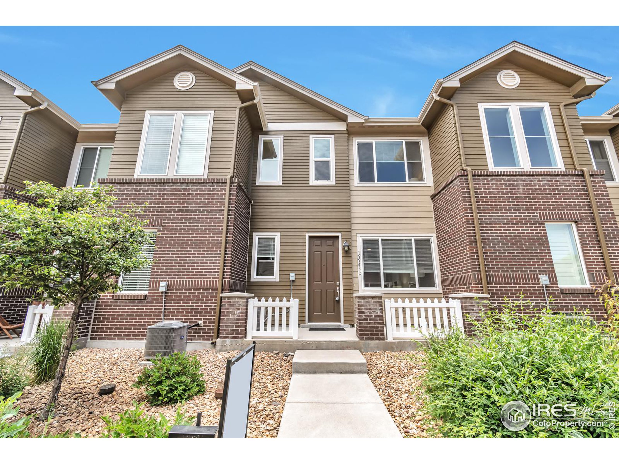 15546 West 64th Loop, Unit C Arvada, CO 80007 - Photo 2 of 27 a front view of a house with a yard