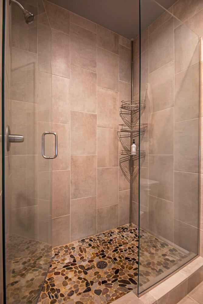 2630 Northwest Boulder Ridge Loop Bend, OR 97703 - Photo 19 of 31 Tile shower with river rock footbed and glass shower doors. Pocket door for privacy.