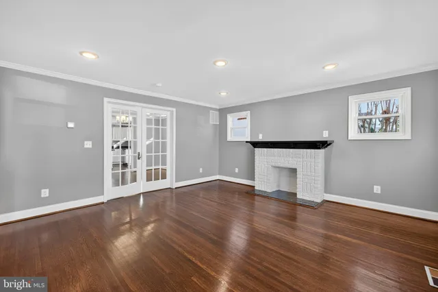 a kitchen with stainless steel appliances granite countertop a refrigerator a sink dishwasher a stove and white countertops with wooden floor