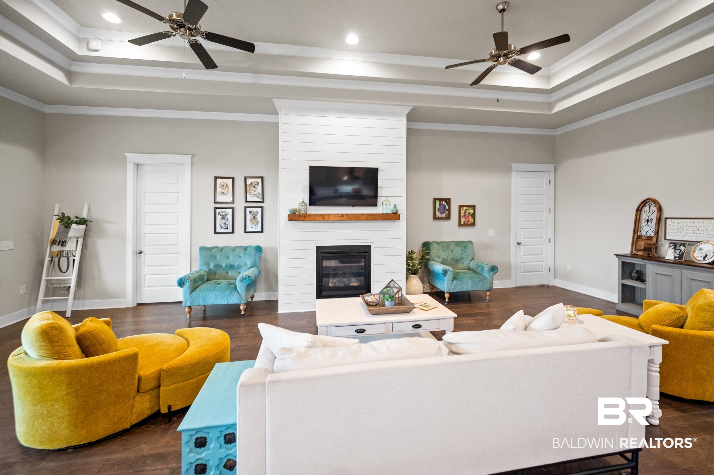 31355 Limpkin Street Daphne, AL 36527 - Photo 27 of 57 Living room with a large fireplace, dark wood-type flooring, a raised ceiling, and ornamental molding