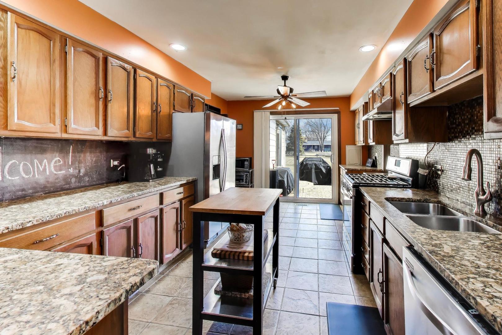 1075 Apricot Street Hoffman Estates, IL 60169 - Photo 7 of 28 a kitchen with stainless steel appliances granite countertop a stove a sink and a microwave