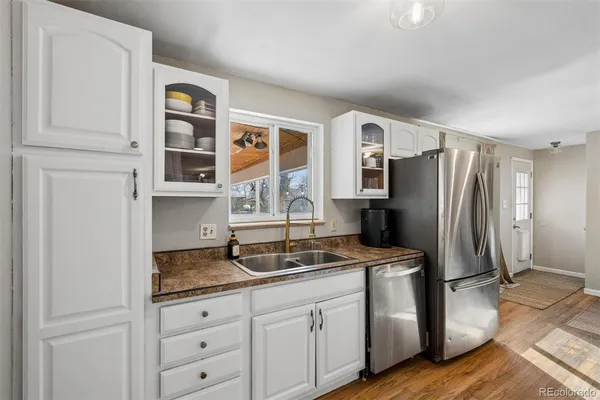 a kitchen with granite countertop a refrigerator and a sink