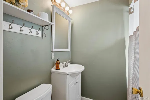 a bathroom with a sink a toilet and mirror