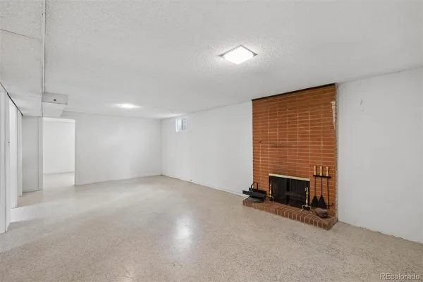 an empty room with a fireplace and window