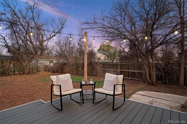 a backyard view of a house with wooden floor and outdoor seating