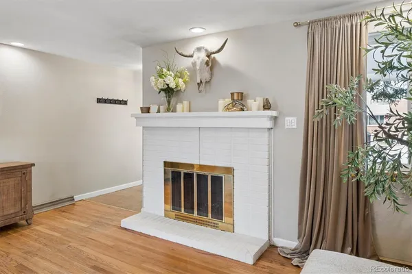 a living room with a fireplace furniture and a potted plant