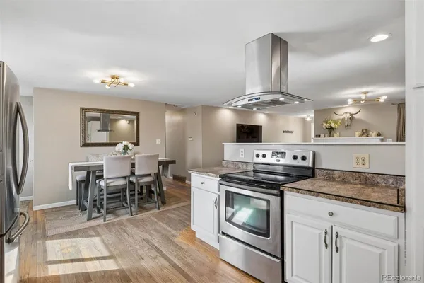 a kitchen with stainless steel appliances granite countertop a stove top oven a sink dishwasher a dining table and chairs