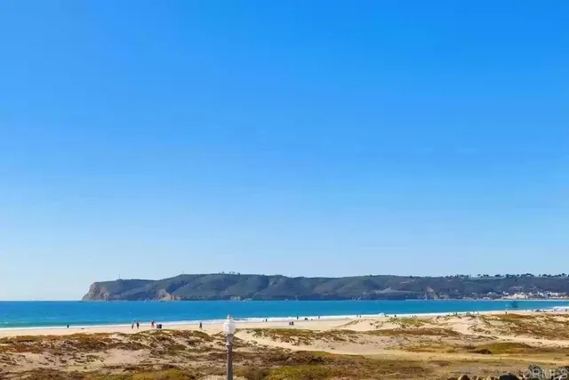 a spacious bedroom with a bed a couch and a large window