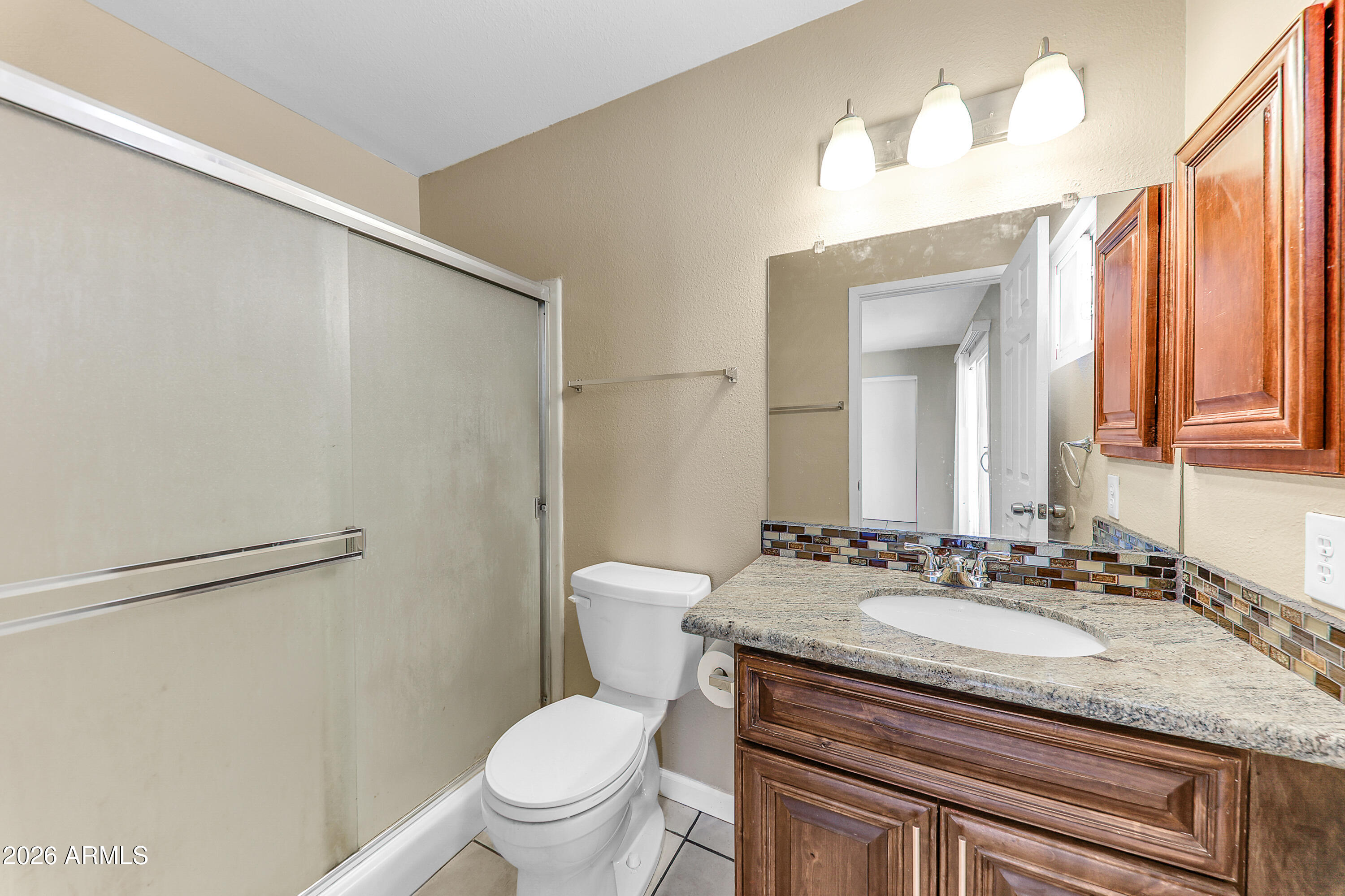 4723 East Vineyard Road Phoenix, AZ 85042 - Photo 19 of 27 a bathroom with a granite countertop sink toilet and a mirror