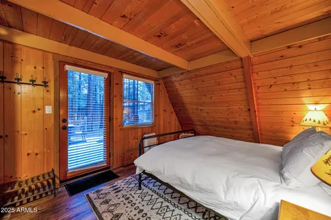 a bedroom with a bed and wooden floor