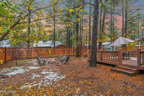 a view of a patio with table and chairs under an umbrella with wooden floor
