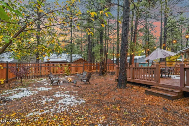a view of a patio with table and chairs under an umbrella with wooden floor