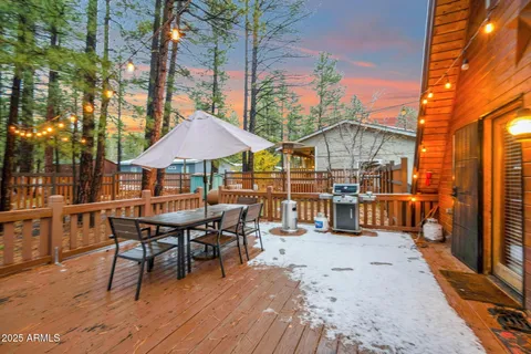 a view of a roof deck with table and chairs under an umbrella with wooden floor