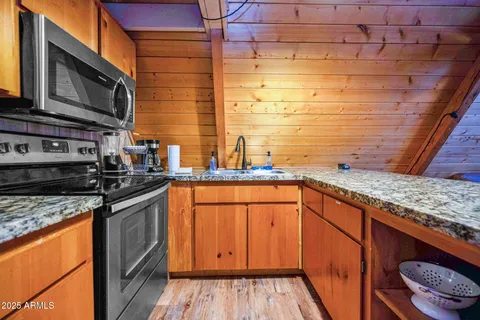a kitchen with stainless steel appliances granite countertop a sink stove and cabinets