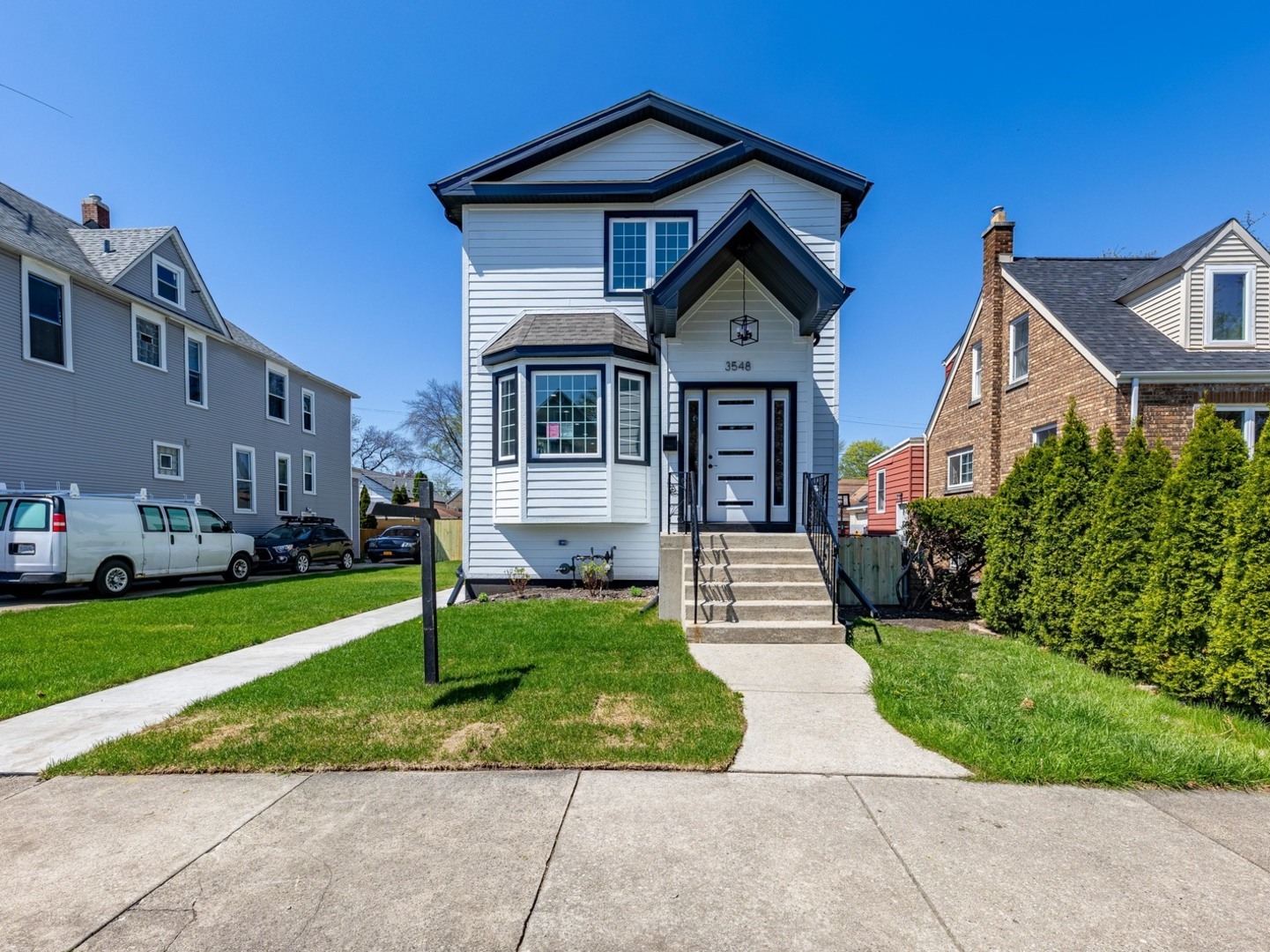 a front view of a house with a yard and trees