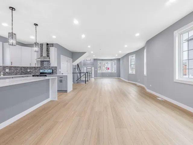 a kitchen with stainless steel appliances granite countertop a sink a stove and a wooden floors