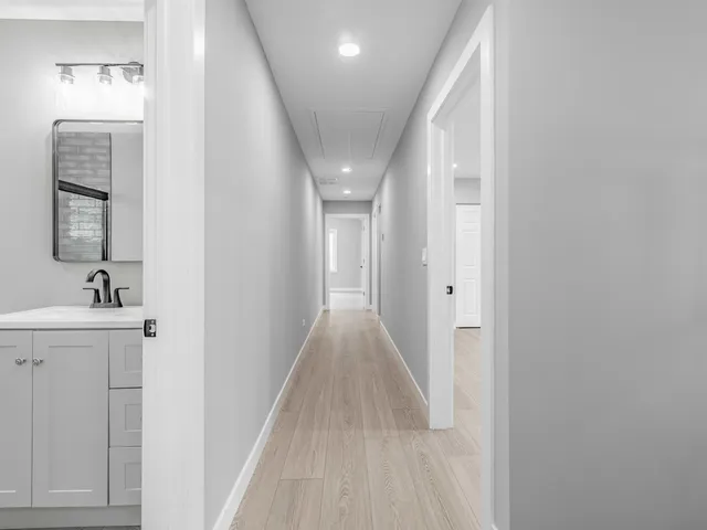 a view of a hallway with wooden floor and staircase