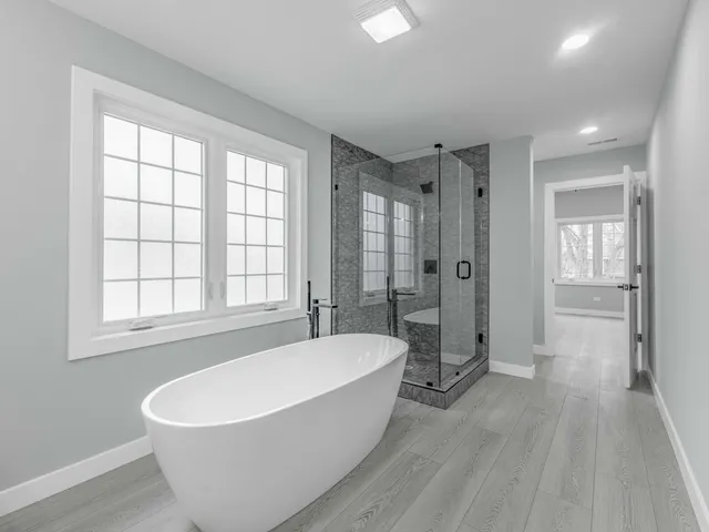a white bath tub sitting in a spacious bathroom with a bathtub and a shower