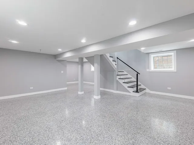 an empty room with windows and stairs