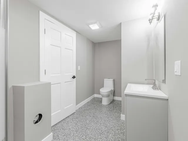 a bathroom with a toilet sink and mirror