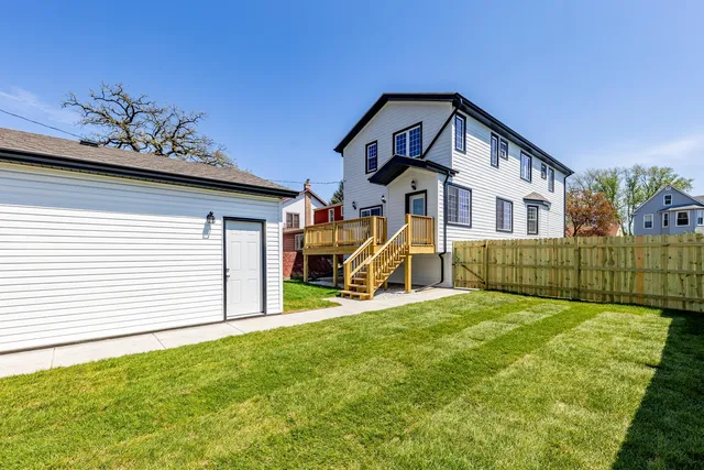 a view of a house with a yard and sitting area