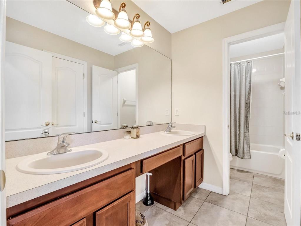 10023 Ians Ridge Road Orlando, FL 32832 - Photo 34 of 60 a bathroom with a sink double vanity and a mirror