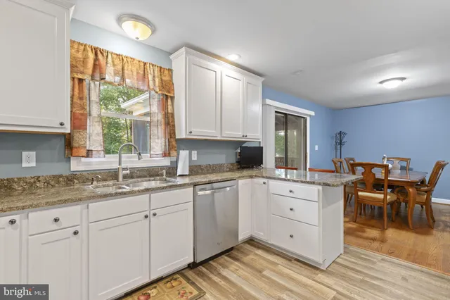a kitchen with granite countertop stainless steel appliances white cabinets granite counter tops and a window
