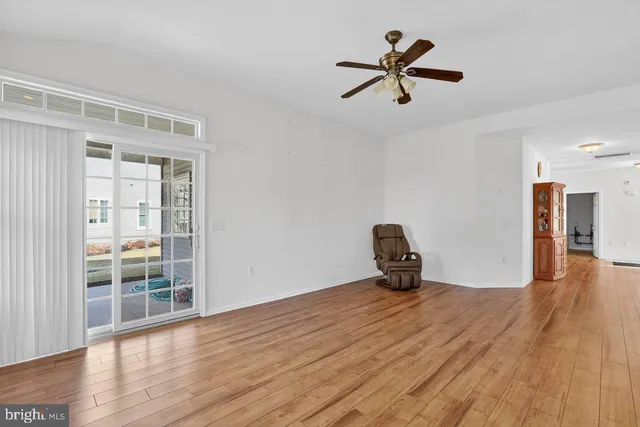 a room with wooden floor and a ceiling fan