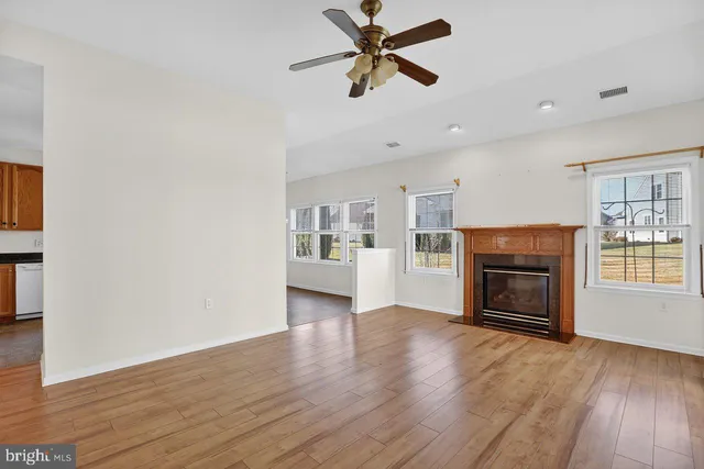 wooden floor fireplace and windows in an empty room