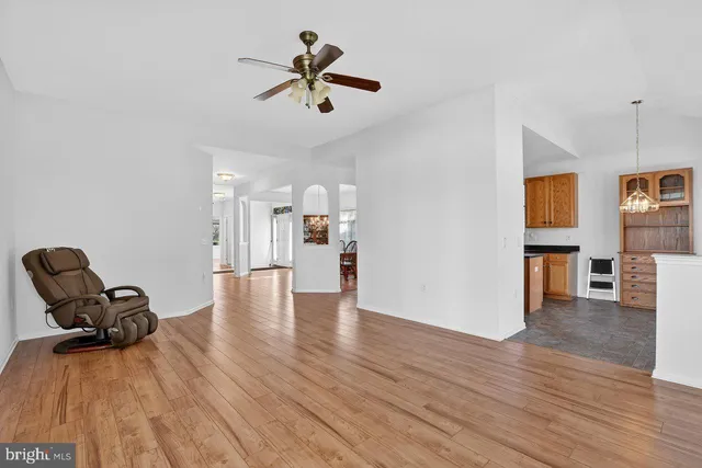 a view of empty room with wooden floor and ceiling fan