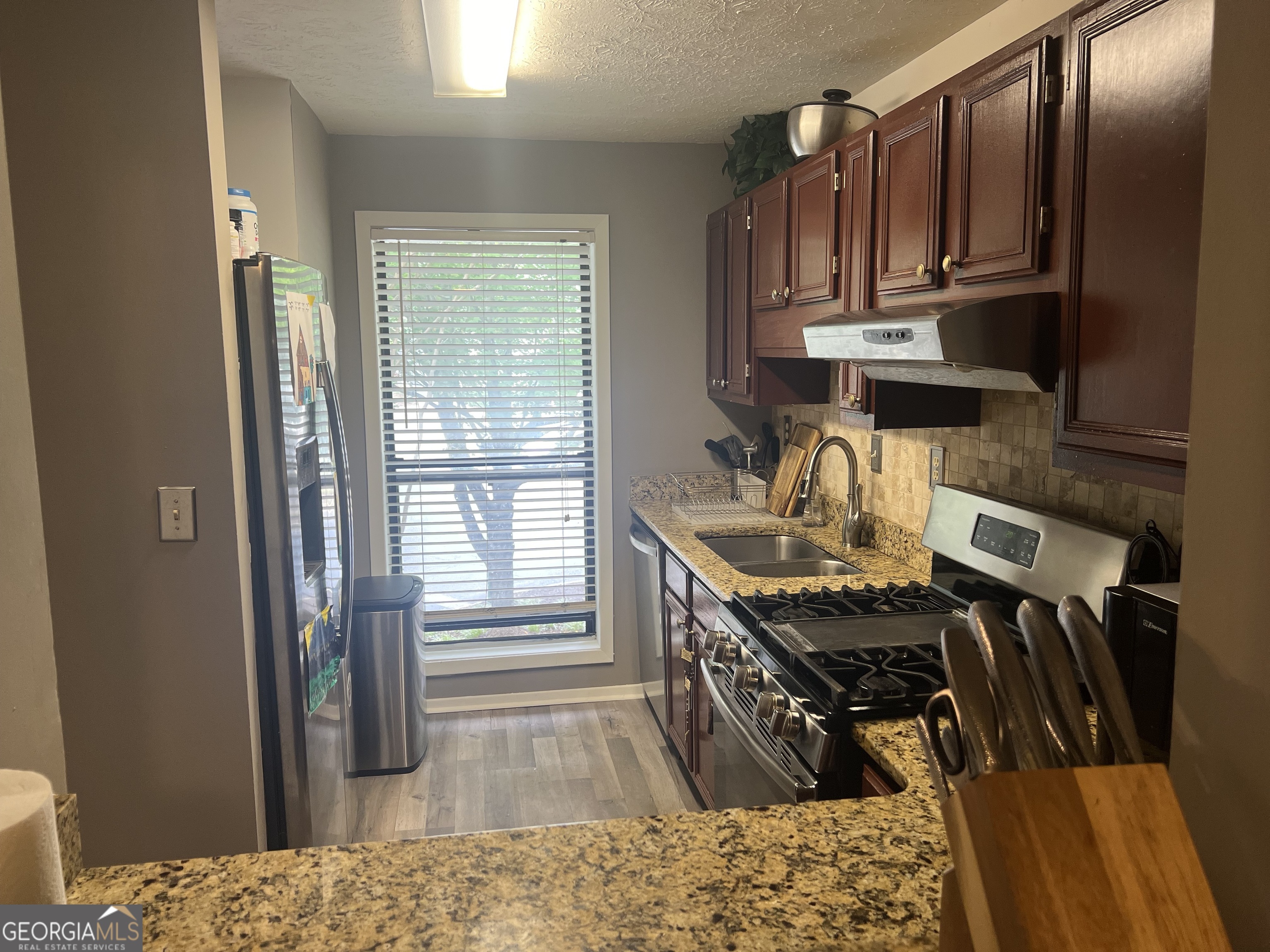 709 Wynnes Ridge Circle Marietta, GA 30067 - Photo 8 of 11 a kitchen with stainless steel appliances granite countertop a stove top oven a sink and dishwasher