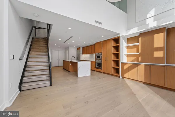 wooden floor in an empty room with a kitchen
