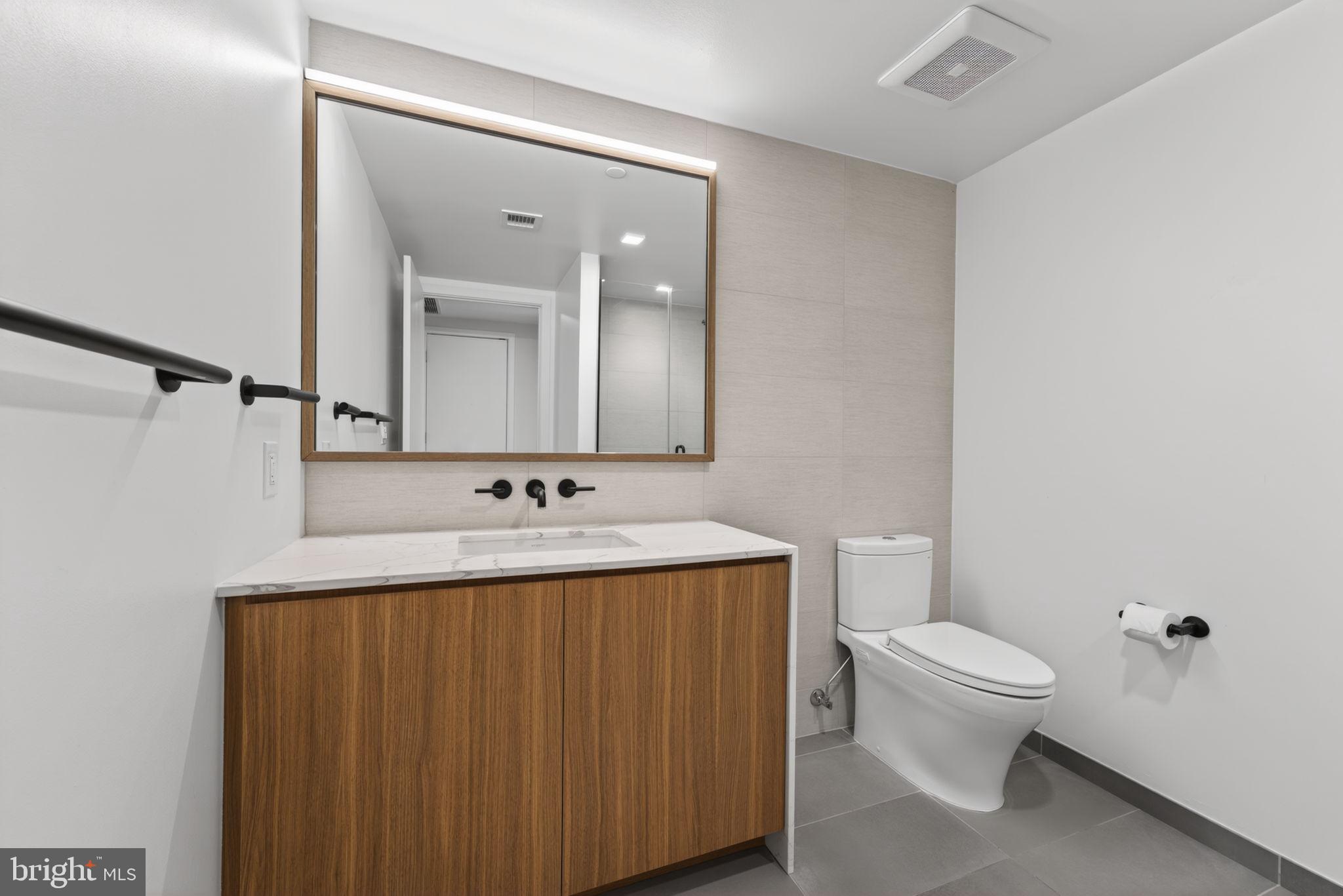 1332 8th Street Northwest Washington, DC 20001 - Photo 31 of 46 a bathroom with a toilet a sink and mirror