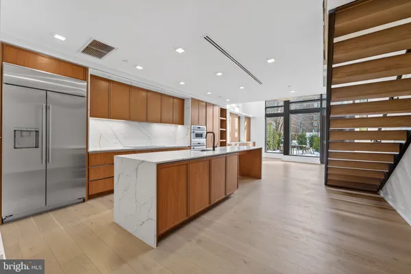 a kitchen with stainless steel appliances granite countertop a refrigerator and a sink