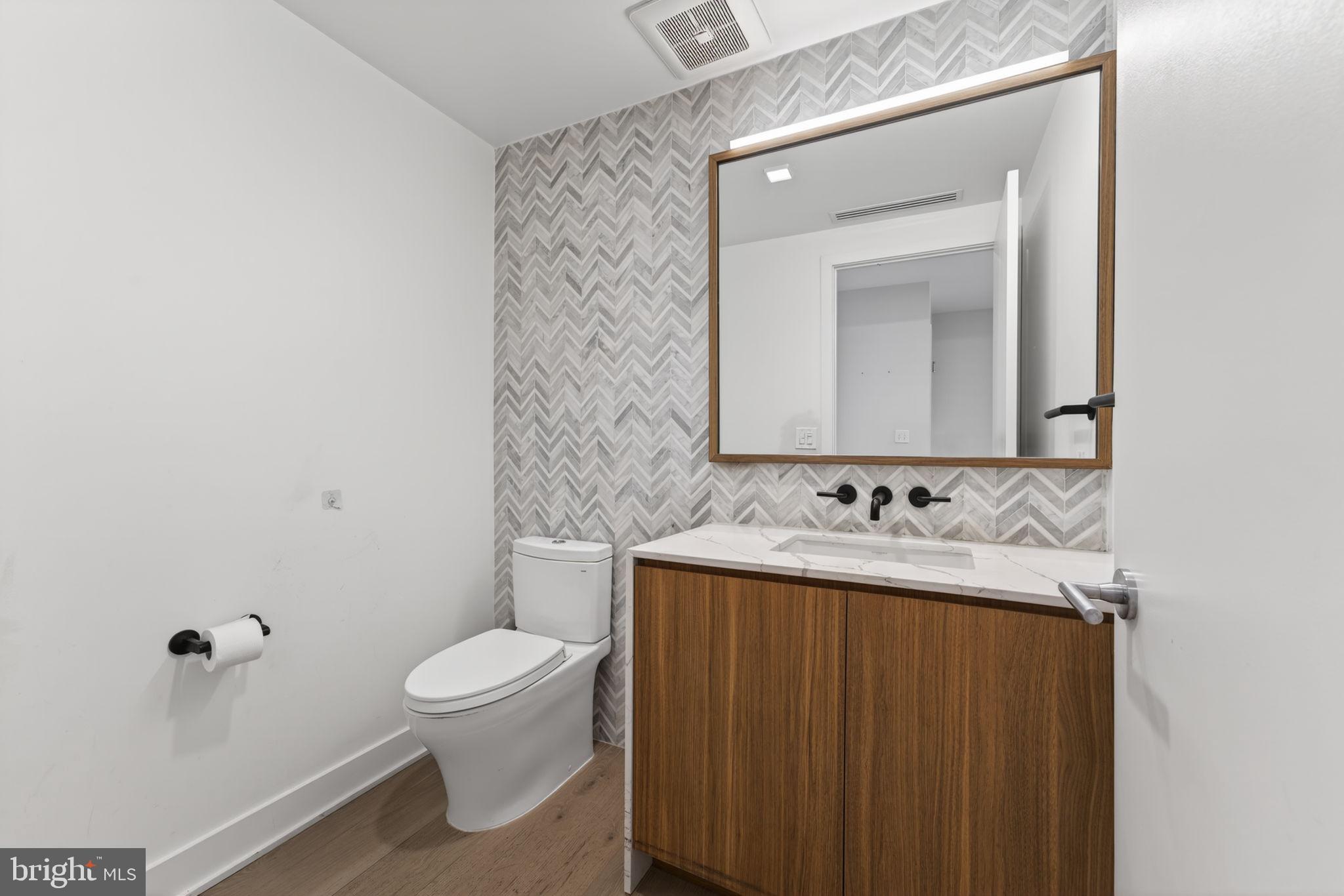 1332 8th Street Northwest Washington, DC 20001 - Photo 9 of 46 a bathroom with a toilet sink and mirror