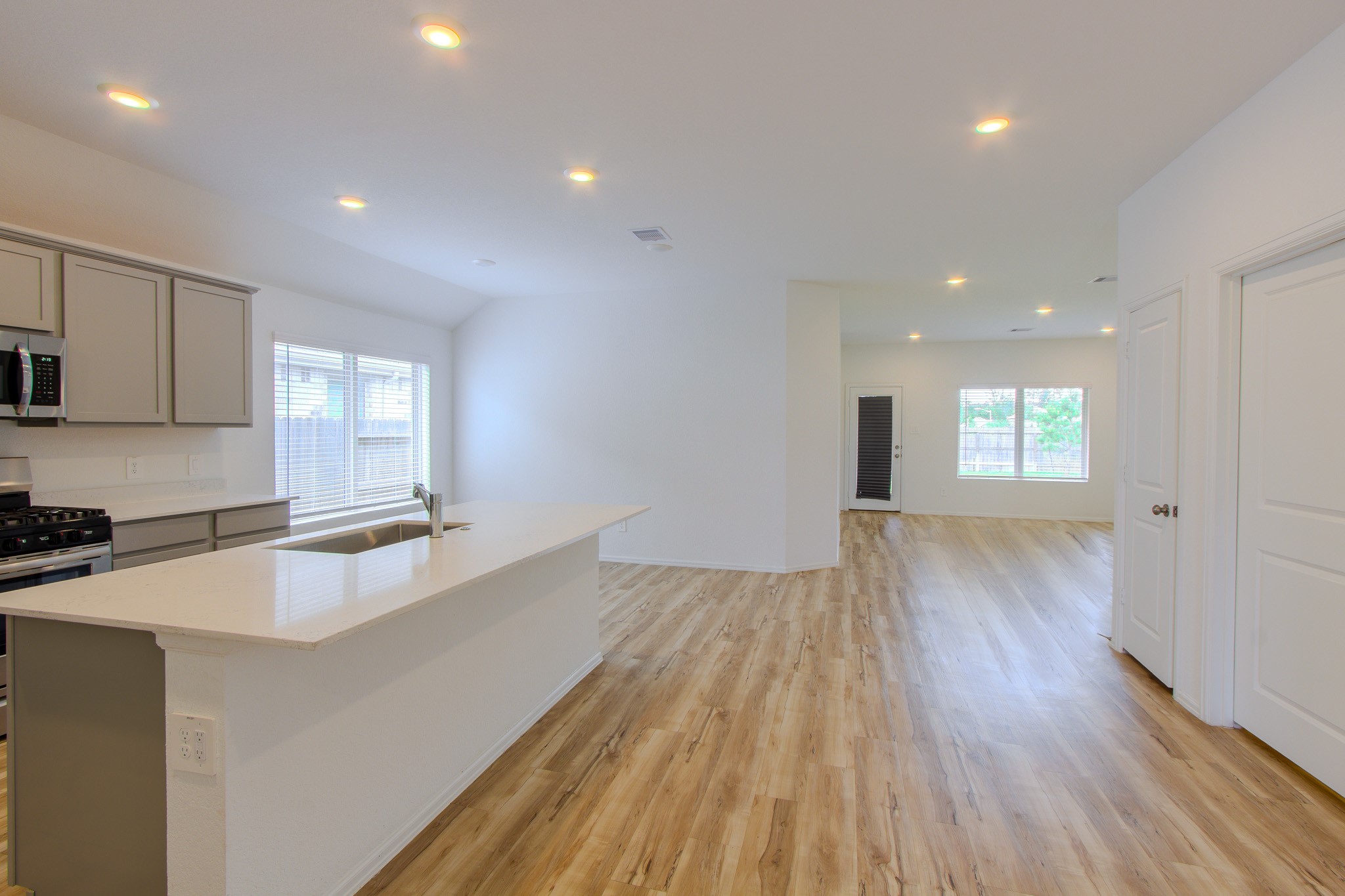 3113 Catalonion Court Conroe, TX 77301 - Photo 15 of 45 a large kitchen with wooden floor and a sink