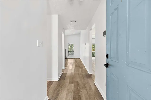 a view of a hallway with wooden floor and staircase