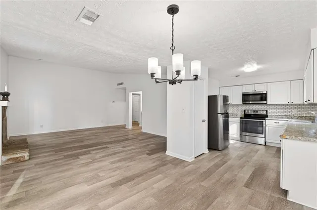 a kitchen with stainless steel appliances granite countertop a refrigerator a stove top oven a sink and dishwasher