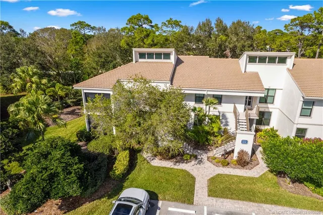aerial view of a house with yard and trees in the background